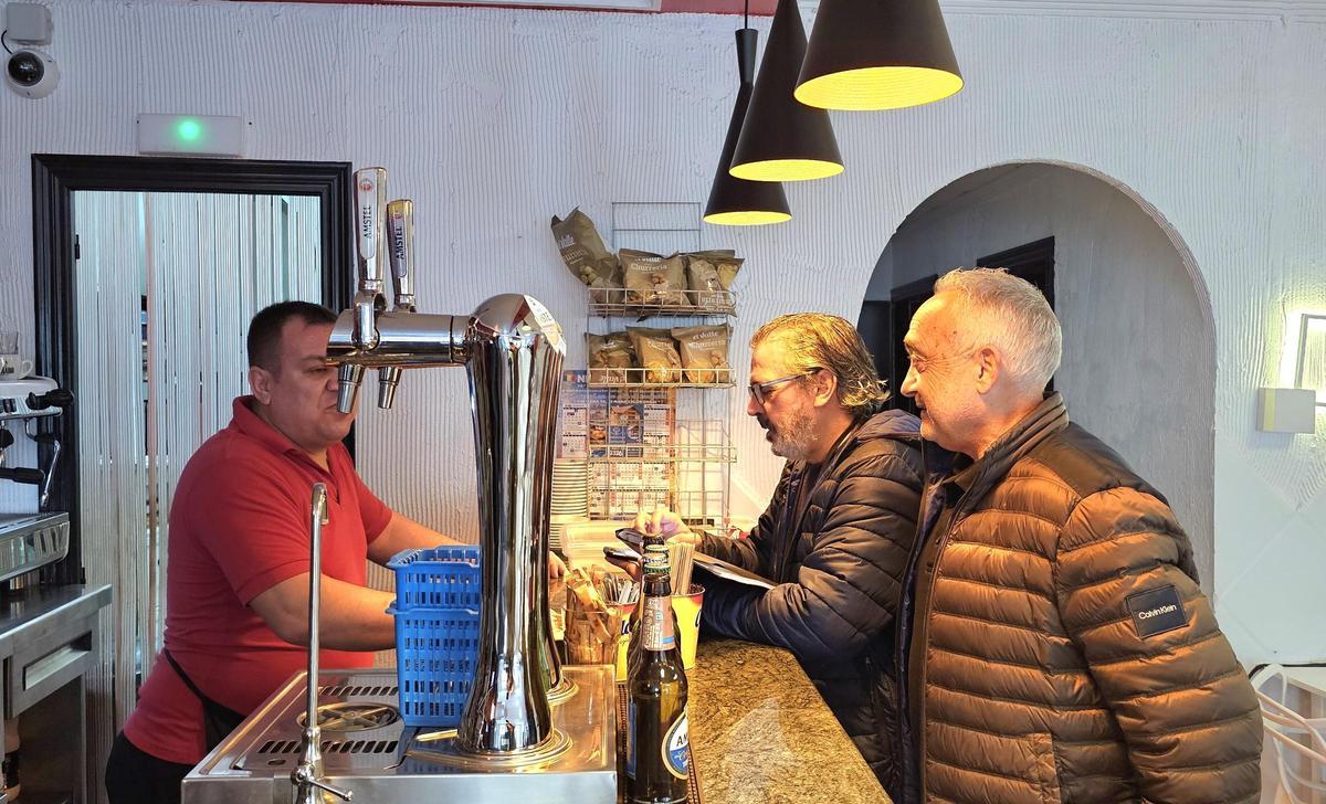 El concejal José Enrique Cuñat y el educador de Ecovidrio informan a un hostelero