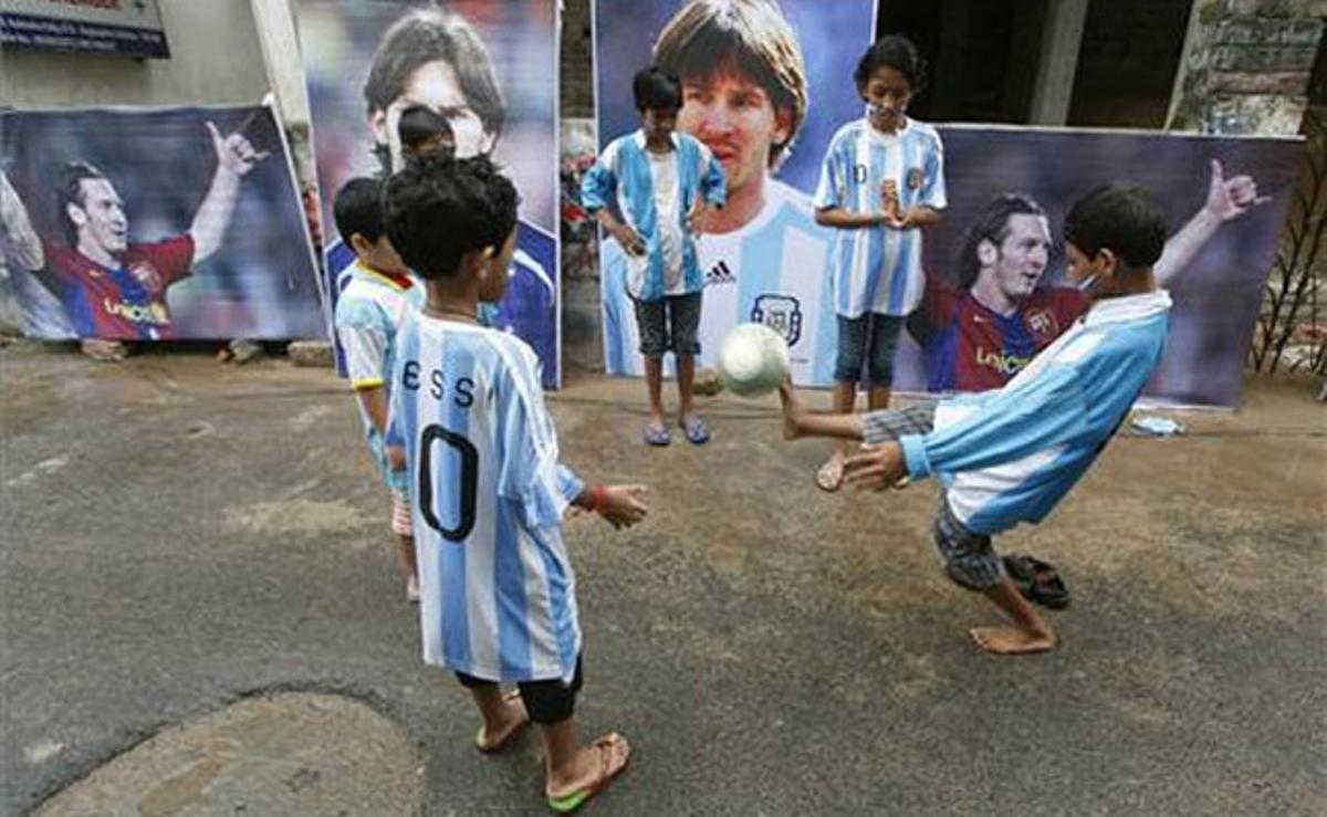 Nens vestits amb samarretes de la selecció argentina juguen a futbol als carrers de Calcuta (Índia).