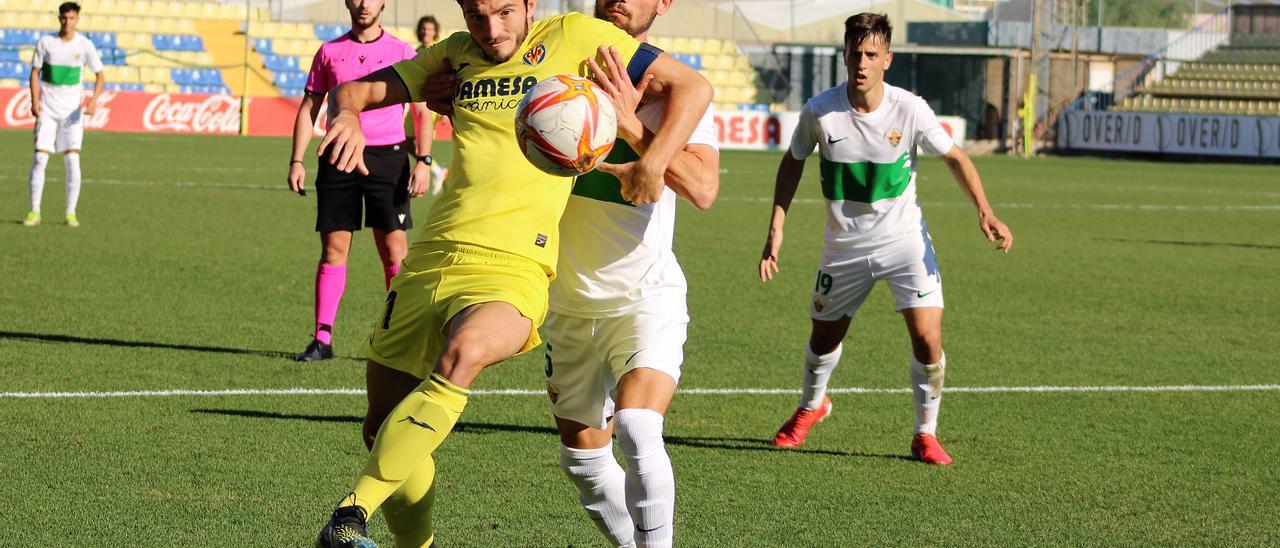 El jugador del Villarreal C disputa el juego ante el Elche B.