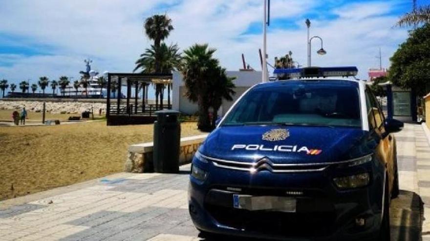 Coche Policía Nacional en el paseo marítimo junto a la playa de Málaga