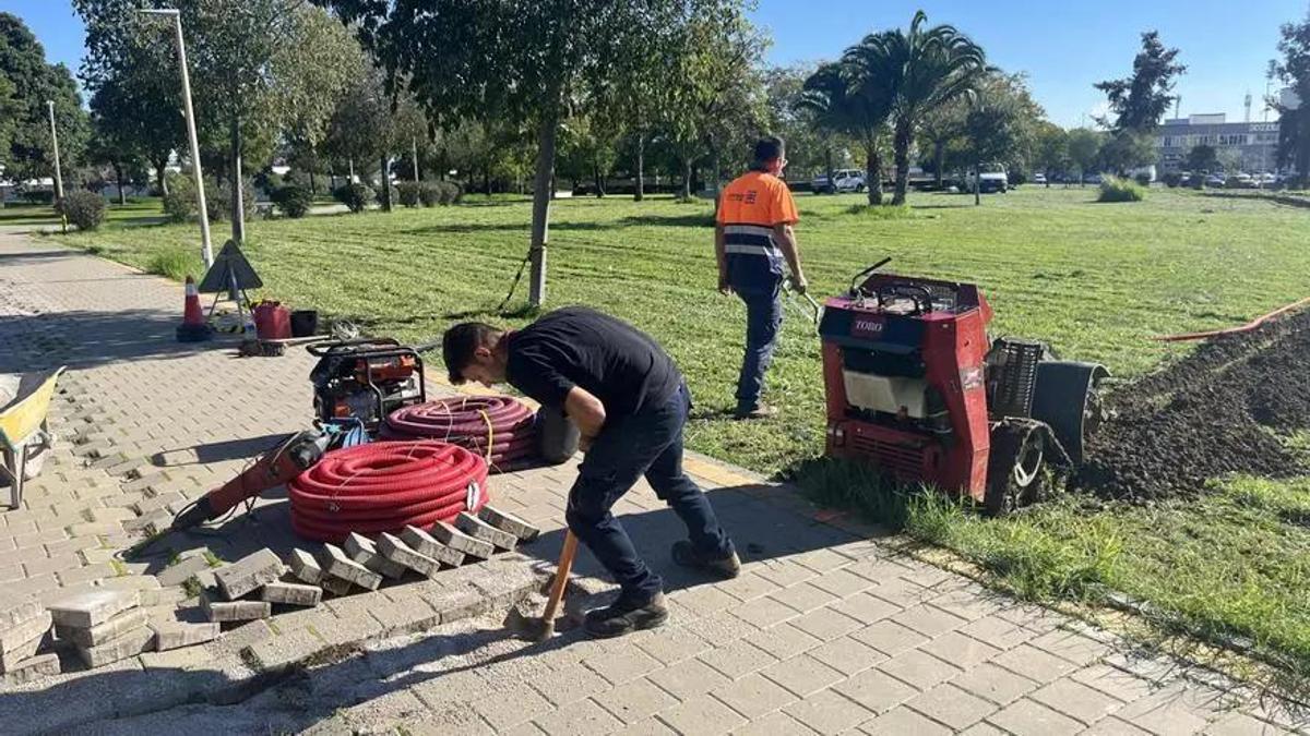 Dos peones del Ayuntamiento de Sevilla trabajando en un jardín.