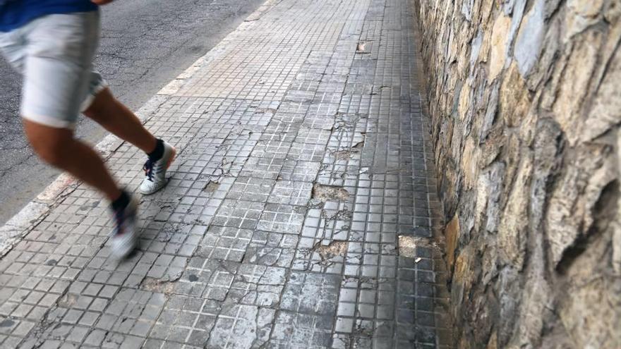 Un corredor pasa junto a varios desperfectos en las baldosas.