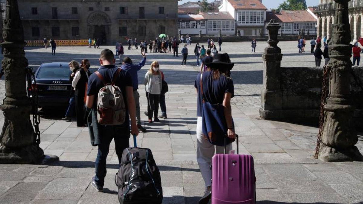 Viajeros con maletas en la praza do Obradoiro.