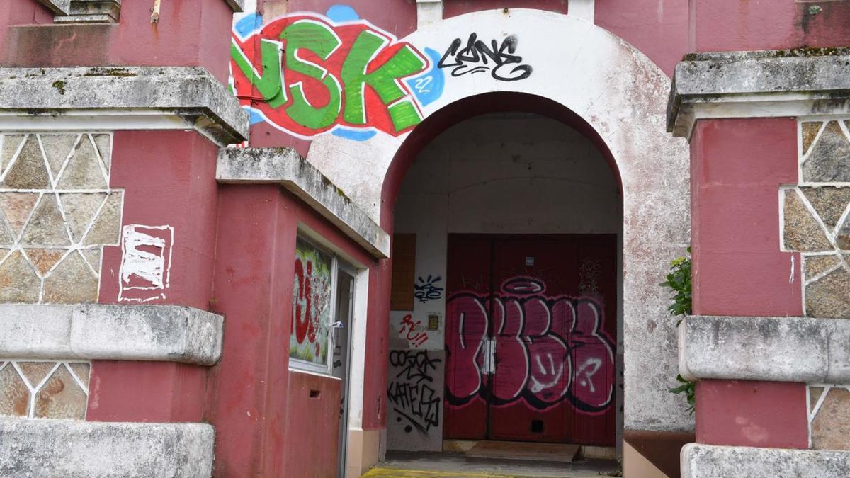 Uno de los grafitis nuevos sobre el arco de entrada a la cárcel, y uno antiguo en la puerta. |   // VÍCTOR ECHAVE