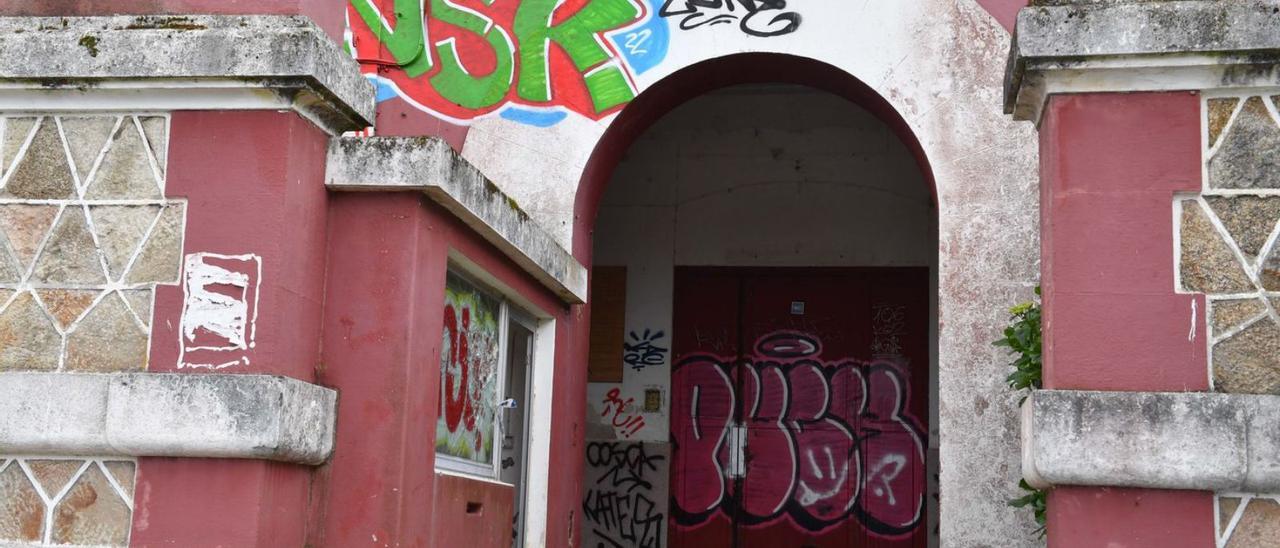 Uno de los grafitis nuevos sobre el arco de entrada a la cárcel, y uno antiguo en la puerta. |   // VÍCTOR ECHAVE