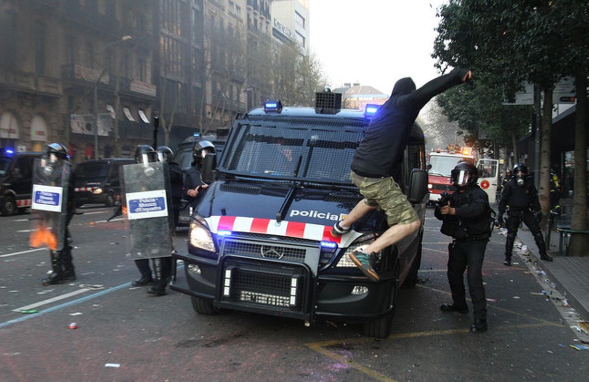 Un manifestante golpea un furgón de los mossos después de la manifestación contra la reforma laboral el 14-N, día de la huelga general.