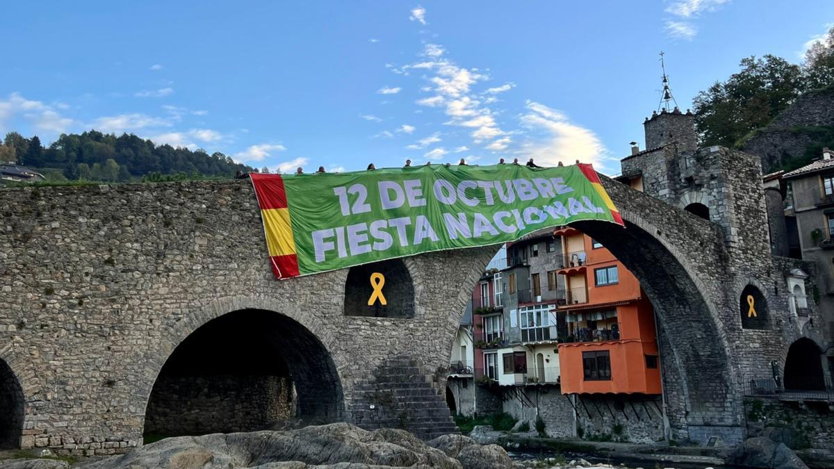 Pancarta de Vox al Pont Nou de Camprodon amb dues banderes espanyoles als laterals i el lema &#039;12 d&#039;octubre. Festa nacional&#039;.