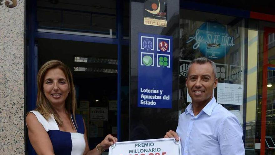 María Luisa Hernández y Daniel Fernández, con el cartel que anuncia el premio de la primitiva.
