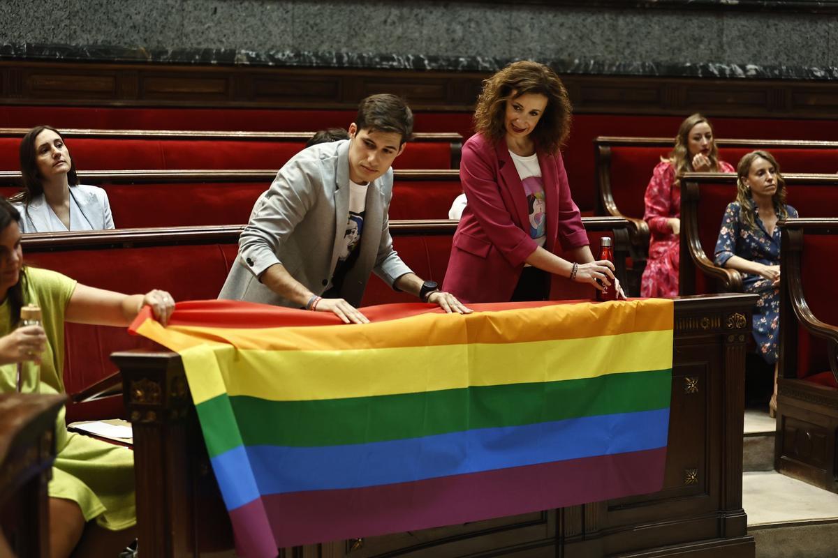 Los concejales socialistas Borja Sanjuán y Maite Ibáñez colocan la bandera arcoiris en su bancada.