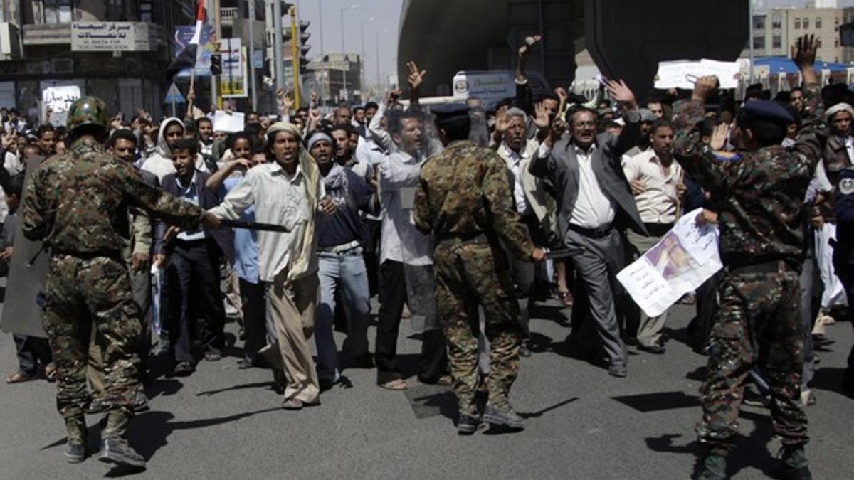 Agentes de policía impiden el acceso de los manifestantes al palacio presidencial, este domingo en Saná.