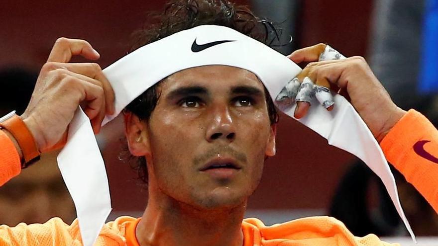 Nadal se coloca la cinta del pelo durante un descanso.