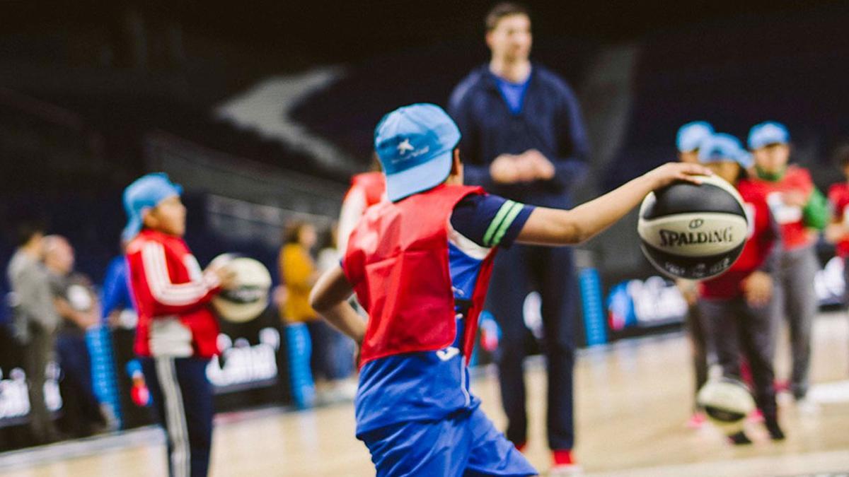 Encuentro entre niños en riesgos de exclusión social y jugadores de baloncesto, en el WiZink Center de Madrid