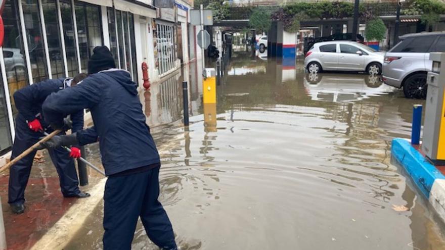 Operarios, ayer, drenan agua en el aparcamiento del Puerto Deportivo de Marbella.
