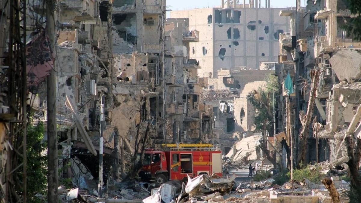 Un camión de bomberos abandonado entre los edificios destruidos por los bombardeos en Deir Ezzor, en una imagen de archivo, en septiembre del 2013.