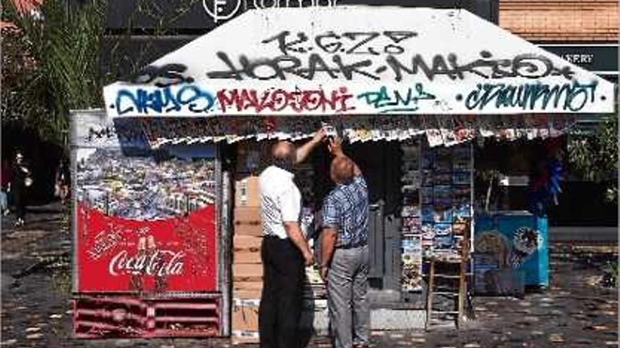 Dos ciutadans grecs llegeixen els titulars de diversos diaris a Atenes.