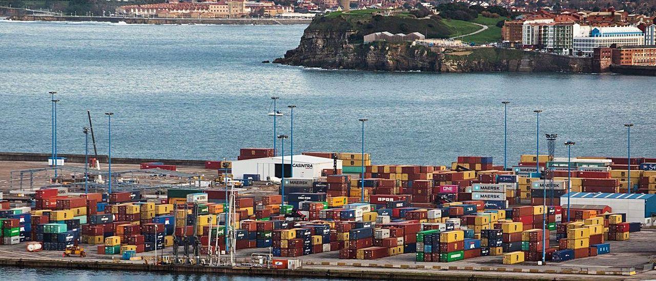 Contenedores apilados en el Muelle de la Osa, en El Musel, con el cerro de Santa Catalina al fondo. / JUAN PLAZA