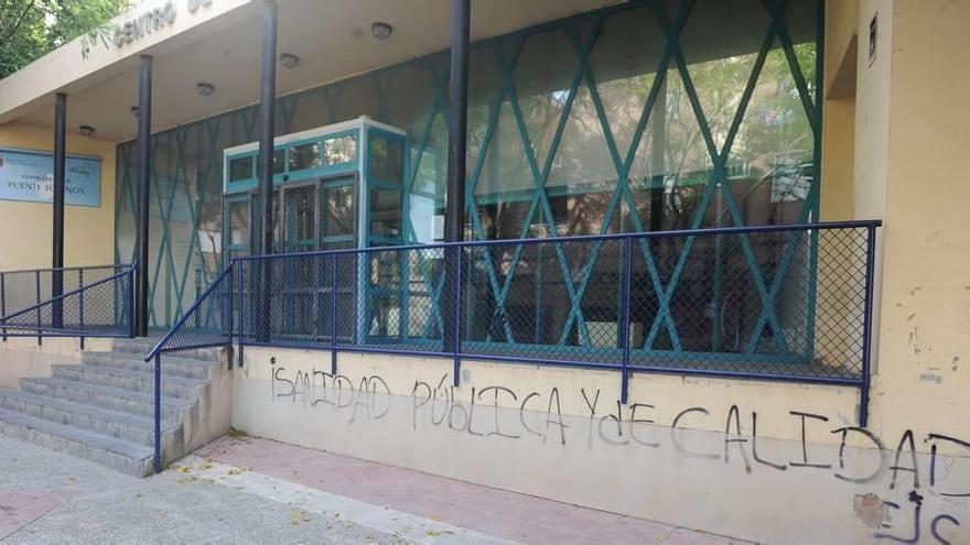 Un grafiti pide en la puerta del centro de salud de Puente Tocinos, unos de los que ha sido cerrado por las tardes, Sanidad Pública de calidad.