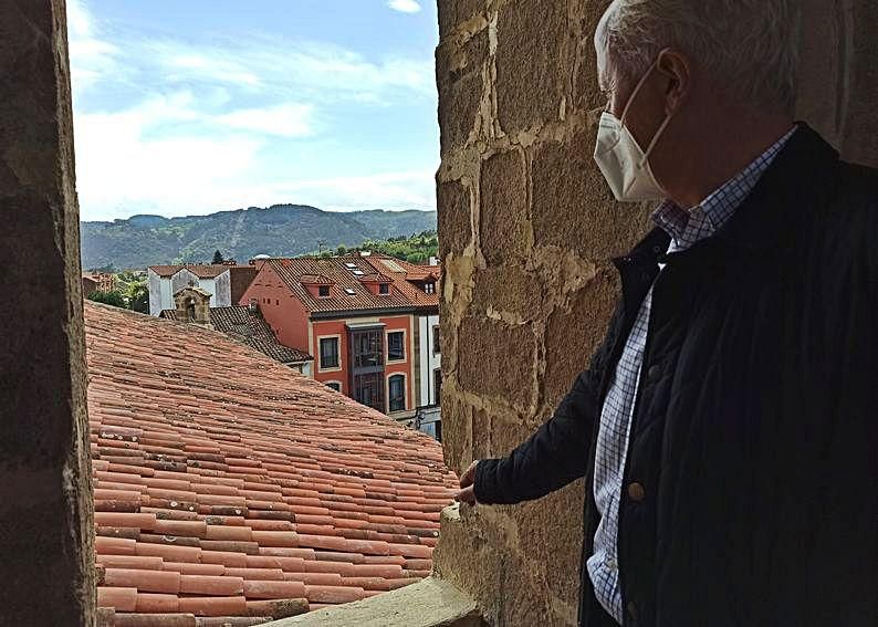 Joaquín Lorences mira la cubierta de la colegiata desde el campanario de la torre.