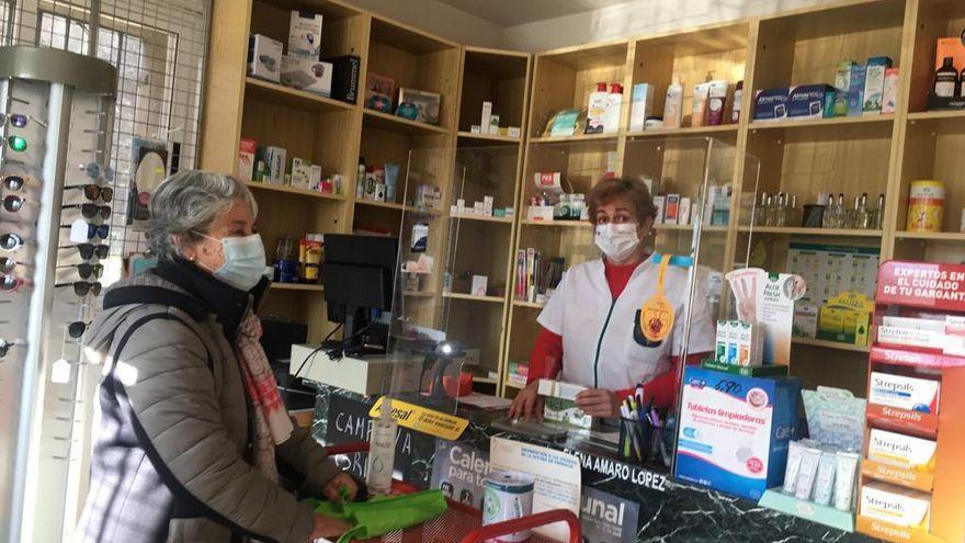 La farmacéutica Elena Amaro en su oficina de Requejo atiende a una cliente.