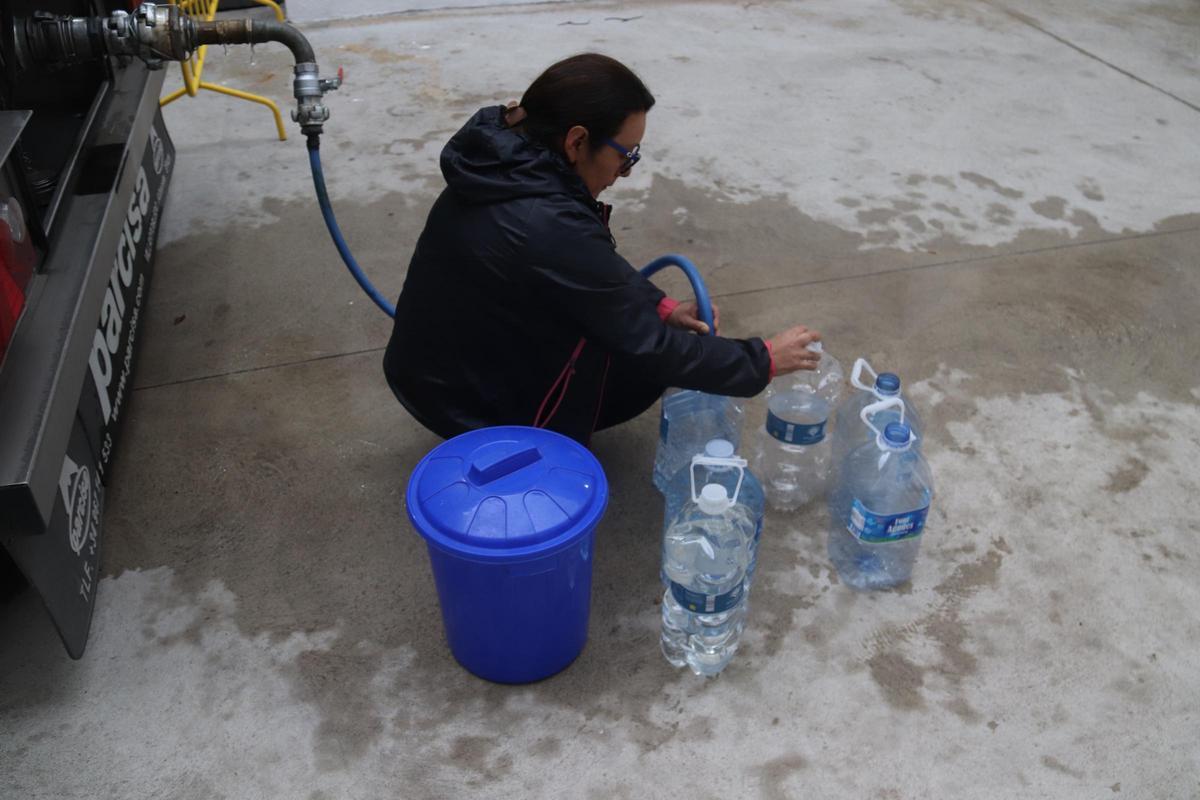 Una veïna omplint garrafes, aquesta setmana a Anglès.