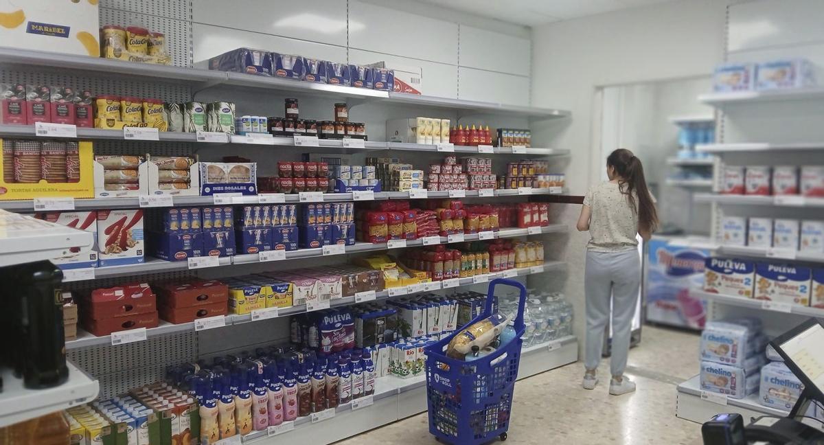 Una joven prepara un carrito de comida en el Economato Social Ecoraiga de Antequera. | L.O