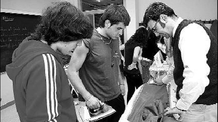 Dos alumnos y un profesor practican en el taller de plancha.