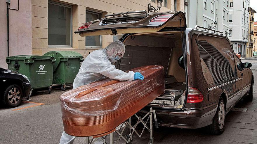 Un operario traslada un féretro a un coche fúnebre, en una imagen de archivo. | BIEL ALIÑO