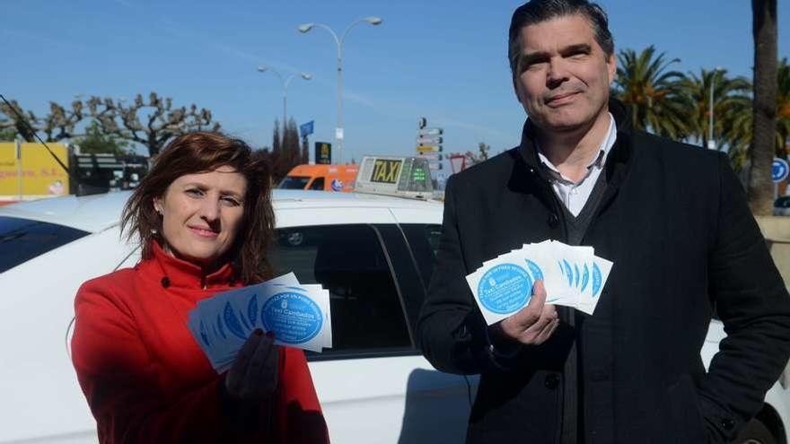 Fátima Abal y Francisco Sierpien mostrando las pegatinas que lucirán en los vehículos. // Noé Parga