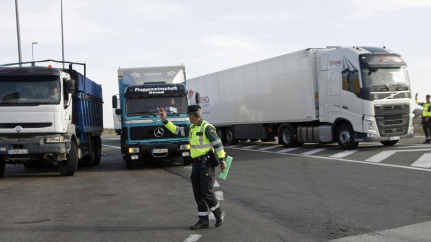 Un agente de la Benemérita guía a un chófer en la explanada habilitada para grandes vehículos en el Puerto de la Cadena, ayer por la tarde.