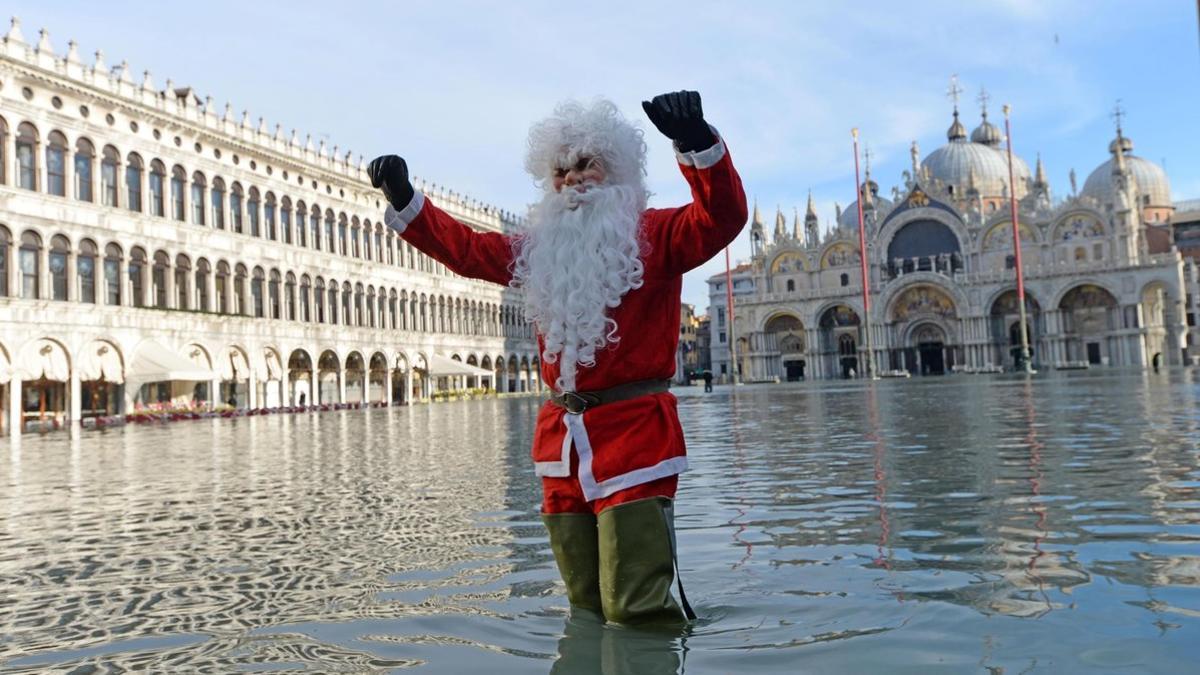 La 'aqua alta'  vuelve a inundar Venecia, un hombre vestido de Santa Claus en la Pza. San Marcos.