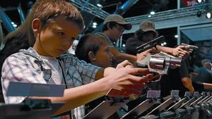 Uns nens proven unes pistoles durant la celebració de la convenció de la NRA, a Houston.