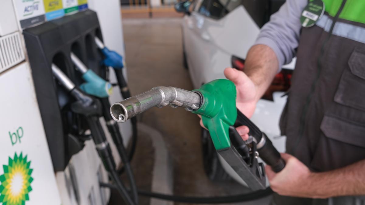 Un trabajador de una gasolinera llena el depósito de un vehículo.