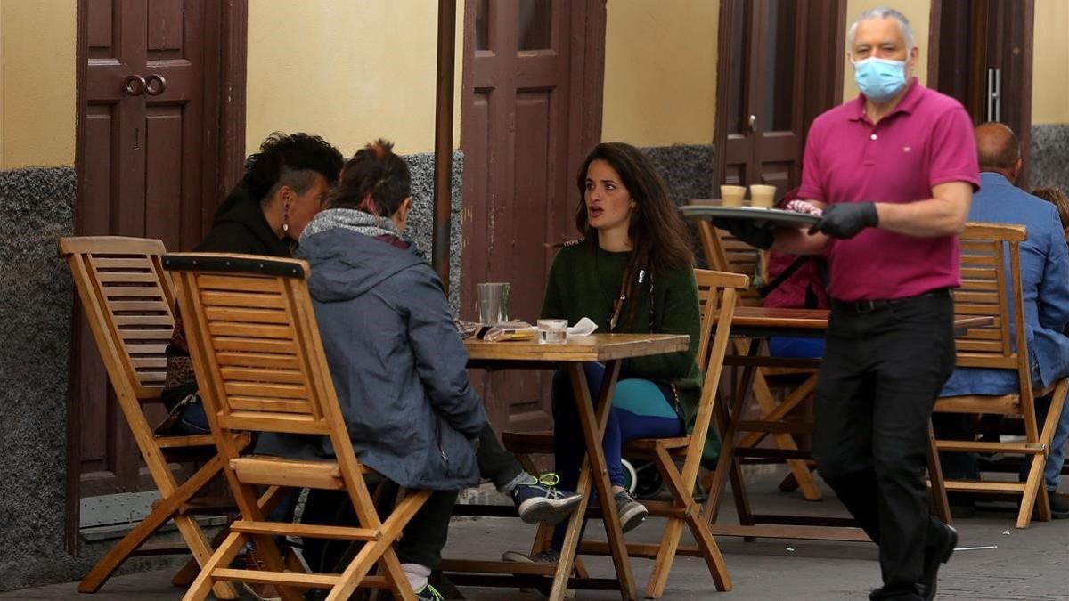 Varios clientes disfrutan de un desayuno en la terraza de un bar, en La Laguna (Tenerife).