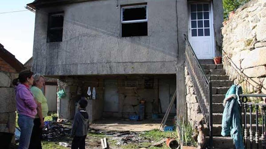 Dos vecinas y un niño, ante la casa en la parroquia de Frades en Mondariz.