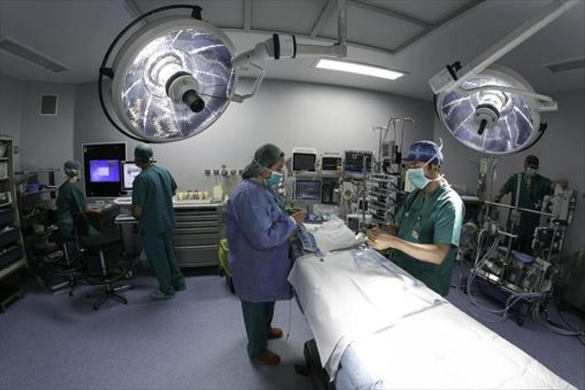 Un equipo médico realiza todos los preparativos en un quirófano antes de una intervención.