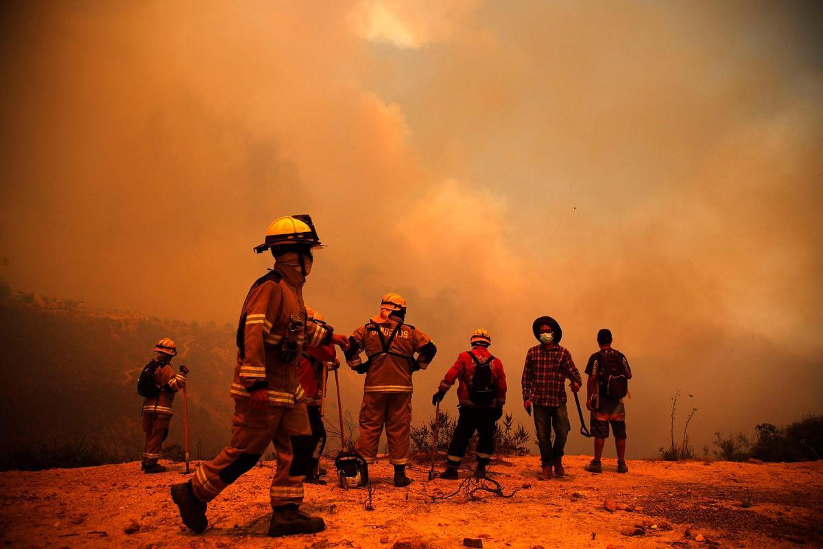 Los bomberos trabajan en la zona de un incendio forestal en las colinas de la comuna de Quilpe, región de Valparaíso, Chile, el 3 de febrero de 2024. La región de Valparaoso y Viña del Mar, en el centro de Chile, se despertó el sábado con un toque de queda parcial para permitir el movimiento de evacuados y traslado de equipos de emergencia en medio de una serie de incendios sin precedentes, informaron las autoridades.