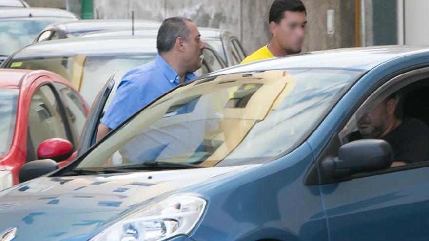 Miguel Ramos, a la izquierda, con camisa azul, sube a un vehículo junto a dos familiares, delante de su casa en Bañaderos.