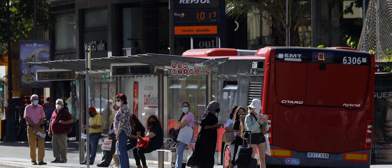 Un grupo de usuarios espera el bus en una parada.