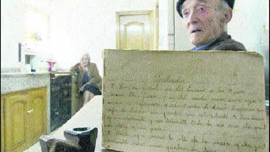 Emilio Fernández Cuervo, ayer, en la cocina de su casa, con la pipa que encontró y su copia de gacetas, que transcribió su mujer, Maruja Vega (al fondo).