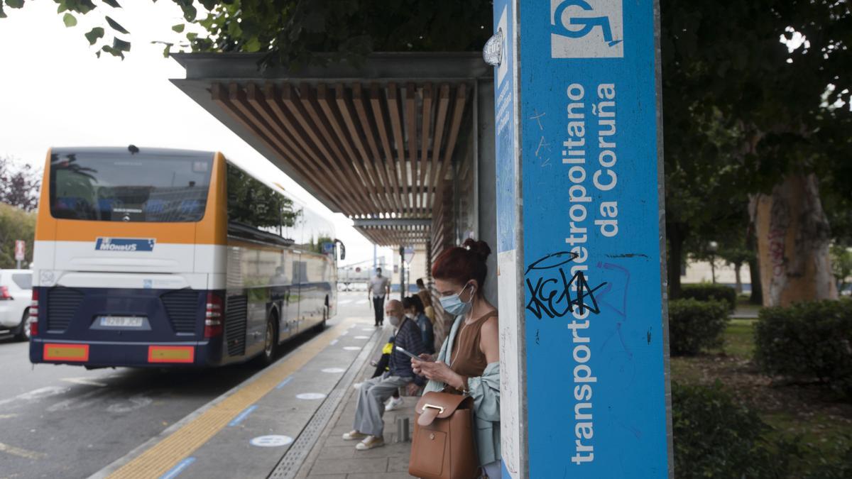 Un bus interurbano y varios usuarios, en la parada de Entrexardíns, en A Coruña.
