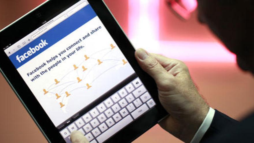 Un hombre consulta Facebook a través de su iPad.