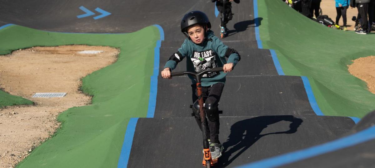 Un niño disfruta del circuito de Pump Track y viste casco y protecciones en codos y rodillas. | J. L. F.