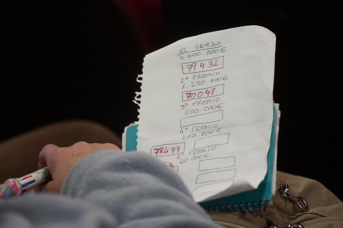 Un hombre apunta los números que van premiando durante la celebración del Sorteo Extraordinario de la Lotería de Navidad 2025.