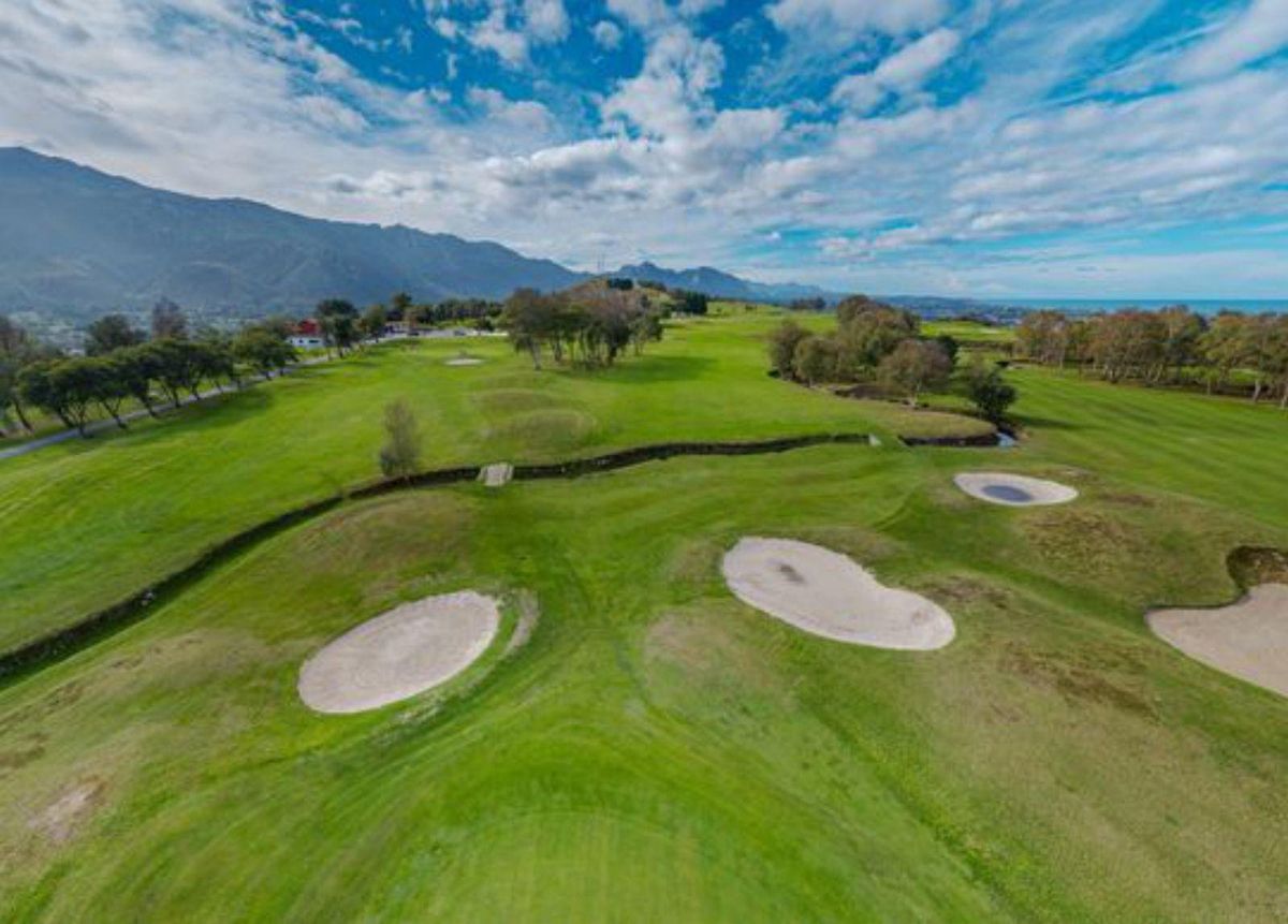 Campo municipal de golf y vista de la playa de Puertu Chicu con la villa de Llanes al fondo. | Cedidas a Lne