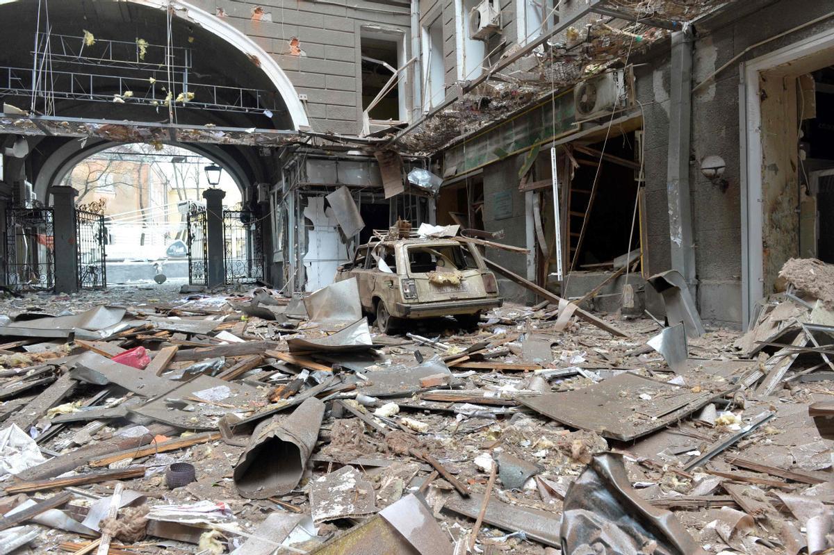 Restos de escombros y un coche destrozado, a la entrada de un edificio en la plaza de la Constitución de Járkov, tras bombardeos rusos.