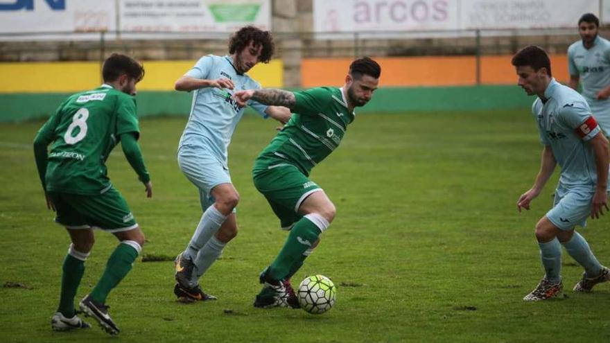 Un jugador del Arenteiro intenta marcharse de un defensor del Villalonga. // Jesús Regal