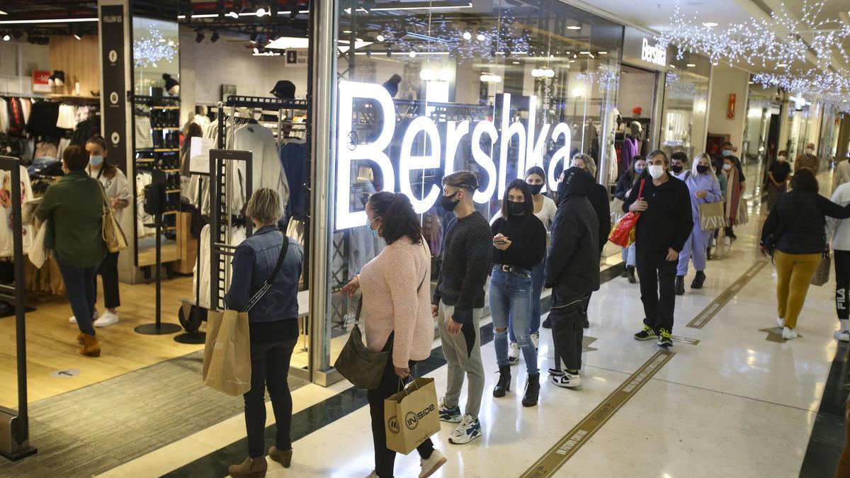 Público haciendo cola para entrar en una tienda en un centro comercial de Alicante, hoy