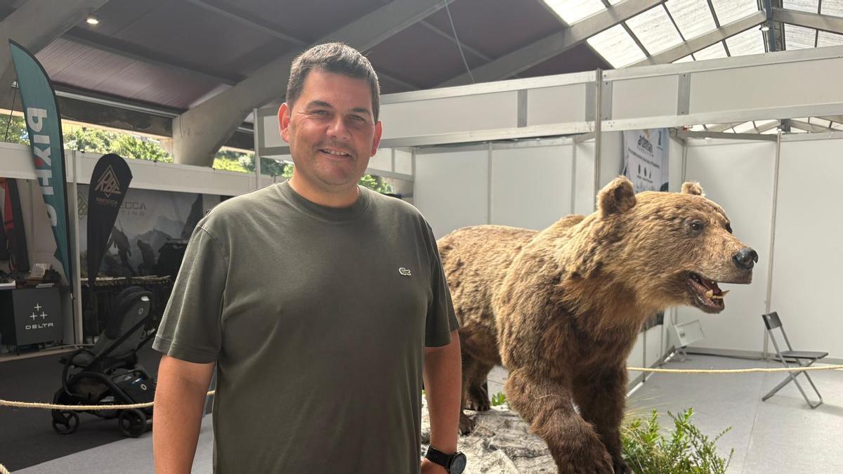 Marcial Fernández al lado del "oso rubio" de Xedré, en el pabellón de la feria.