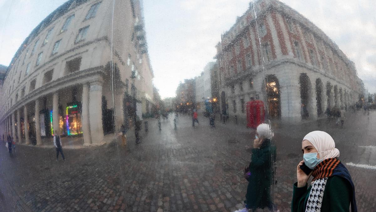 Una mujer con mascarilla en el centro de Londres