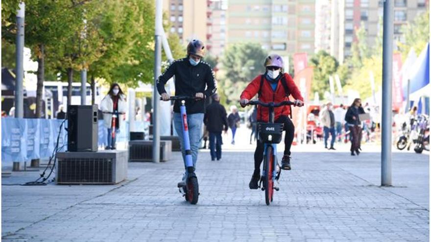 Un hombre circula con un patinete de Dott junto a un ciclista